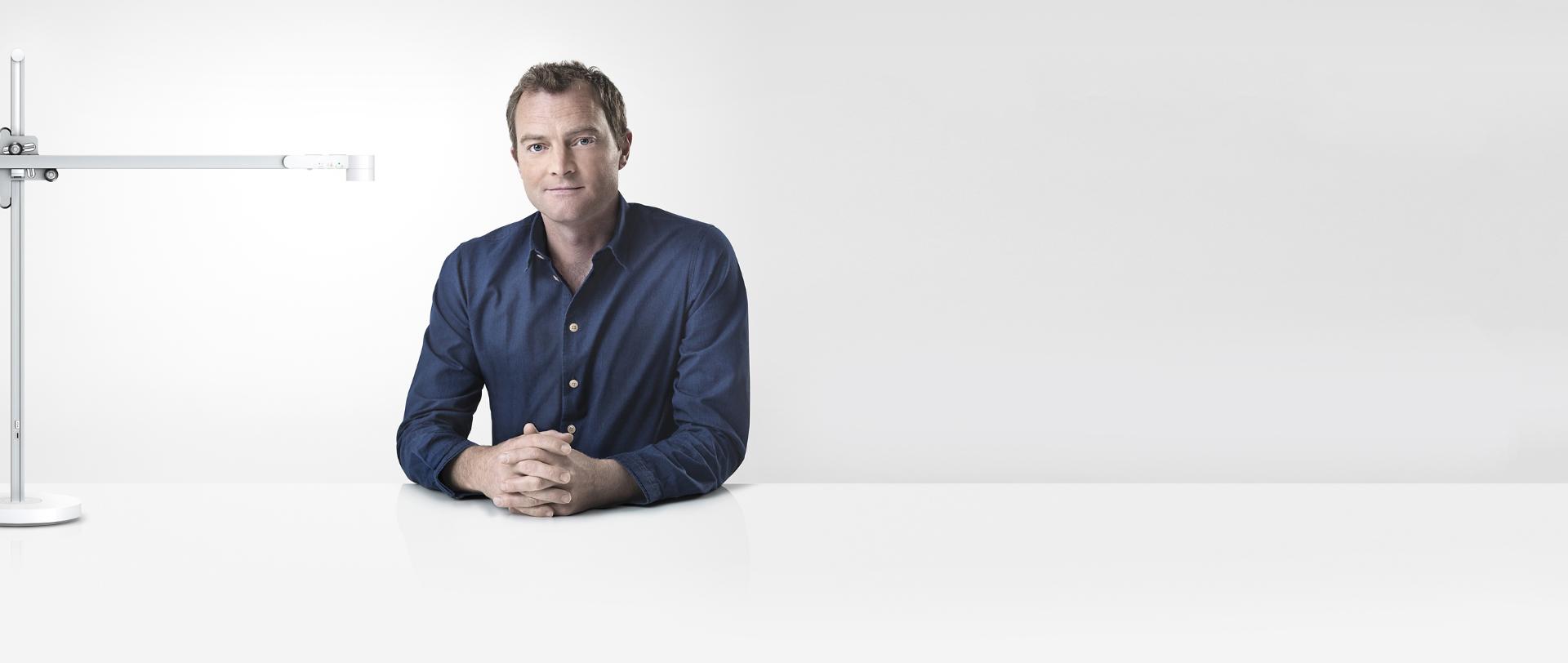 Jake Dyson sitting next to the Dyson Lightcycle™ task light