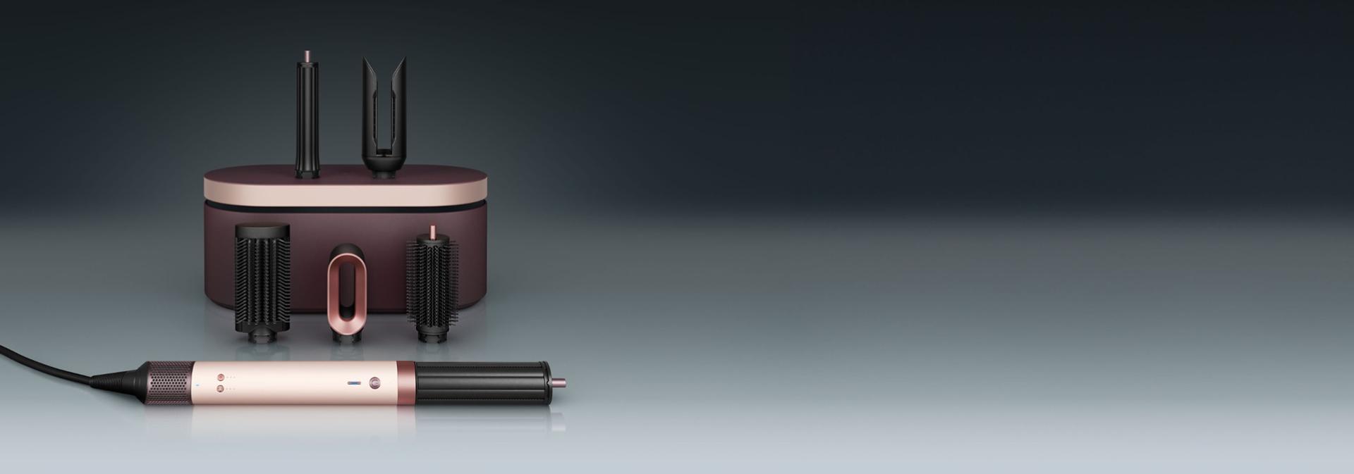 مجفف ومصفف Dyson Airwrap Co-anda2x متعدد الوظائف أمام علبة تقديم مع مجموعة من الملحقات.