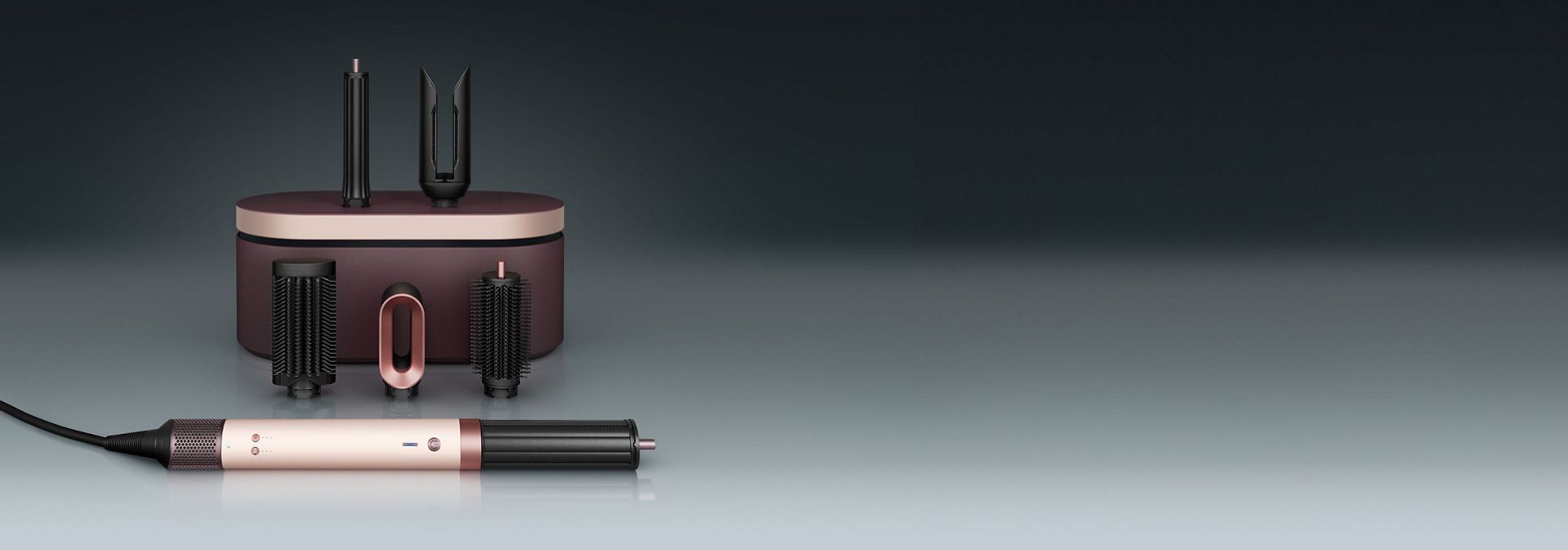 مجفف ومصفف Dyson Airwrap Co-anda2x متعدد الوظائف أمام علبة تقديم مع مجموعة من الملحقات.