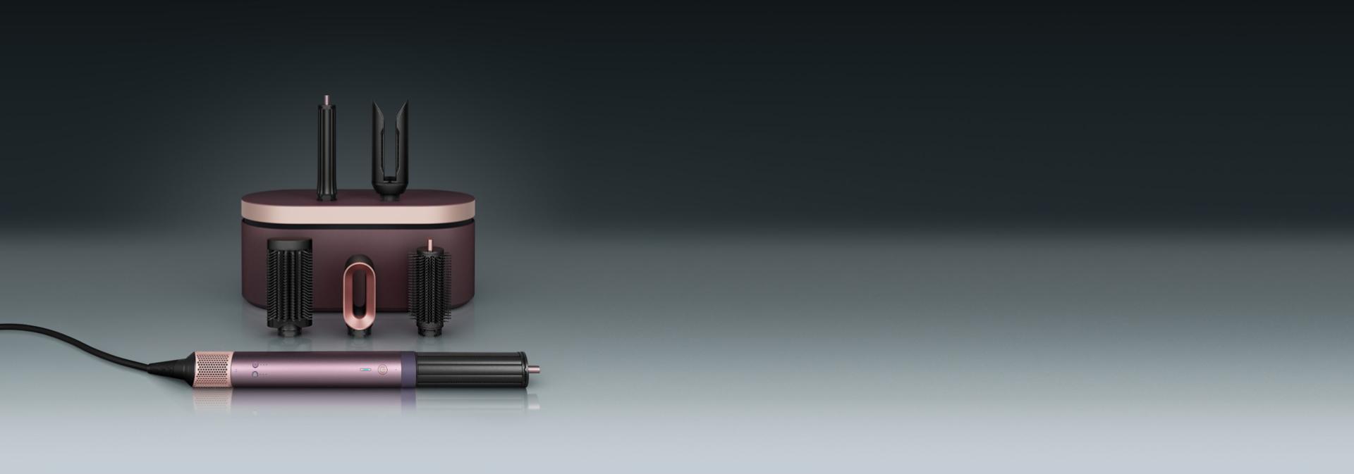 مجفف ومصفف Dyson Airwrap Co-anda2x متعدد الوظائف أمام علبة تقديم مع مجموعة من الملحقات.