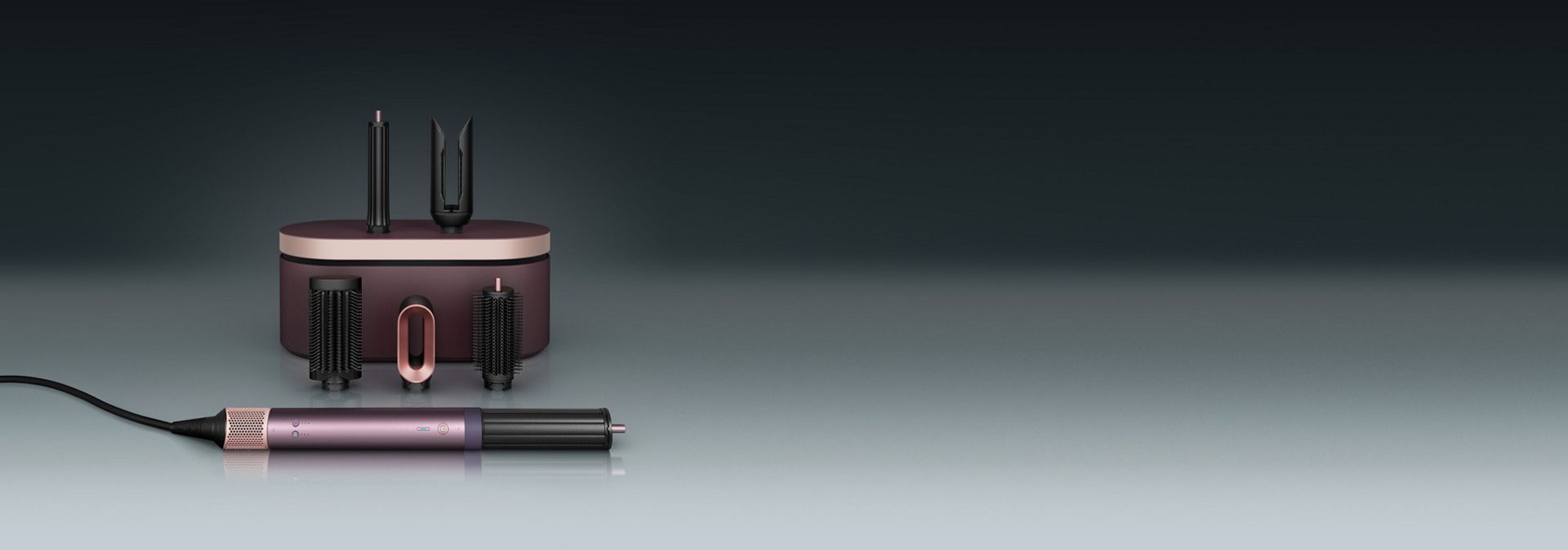 مجفف ومصفف Dyson Airwrap Co-anda2x متعدد الوظائف أمام علبة تقديم مع مجموعة من الملحقات.