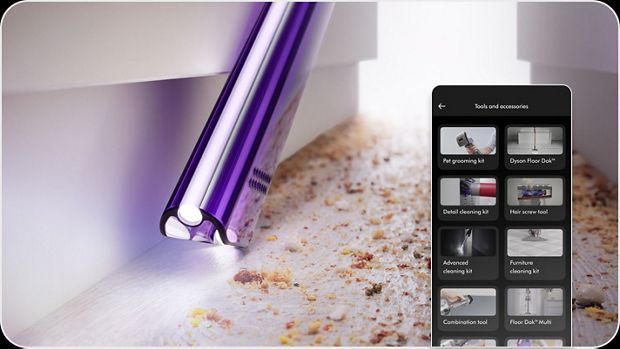 An owner vacuuming between furniture with the MyDyson app showing varying attachments for their Dyson vacuum cleaner. 