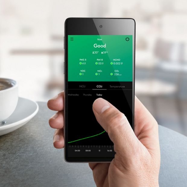 يد تحمل هاتفاً جوالاً مع عرض الشاشة الرئيسية للتطبيق