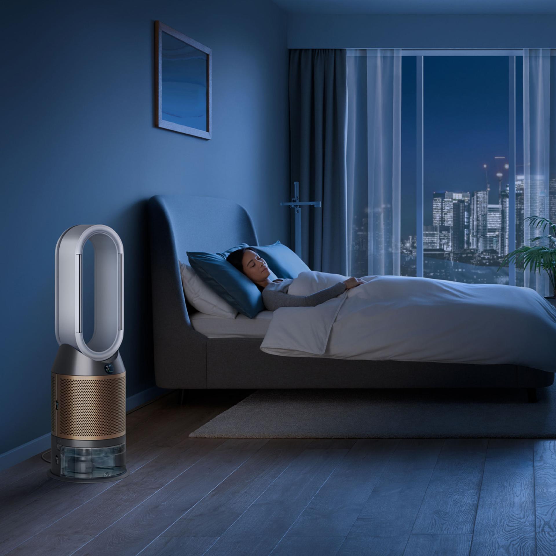 A purifier humidfier in a bedroom, purifying and hydrating air at night while a person sleeps
