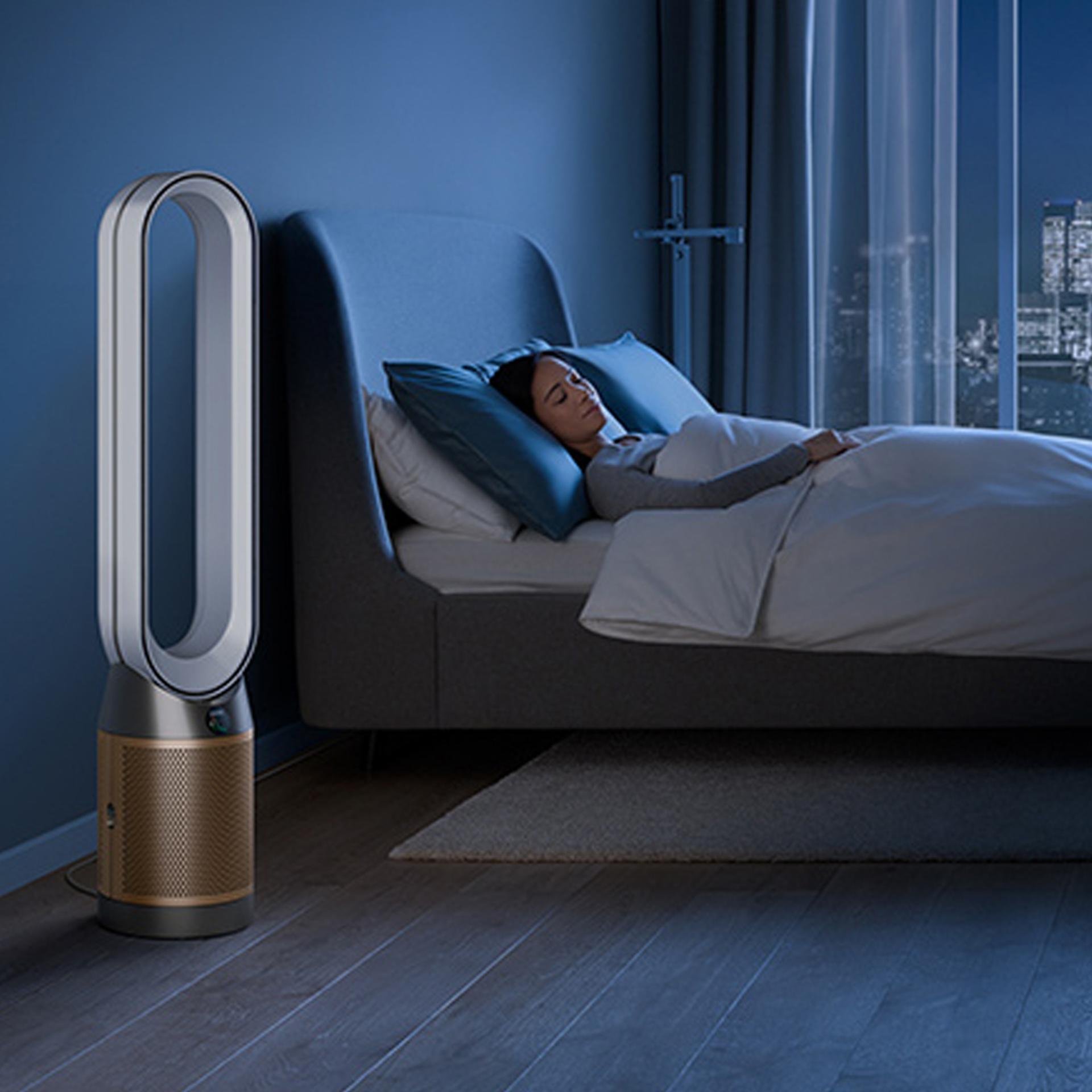A Dyson purifier in a bedroom, purifying air at night while a person sleeps