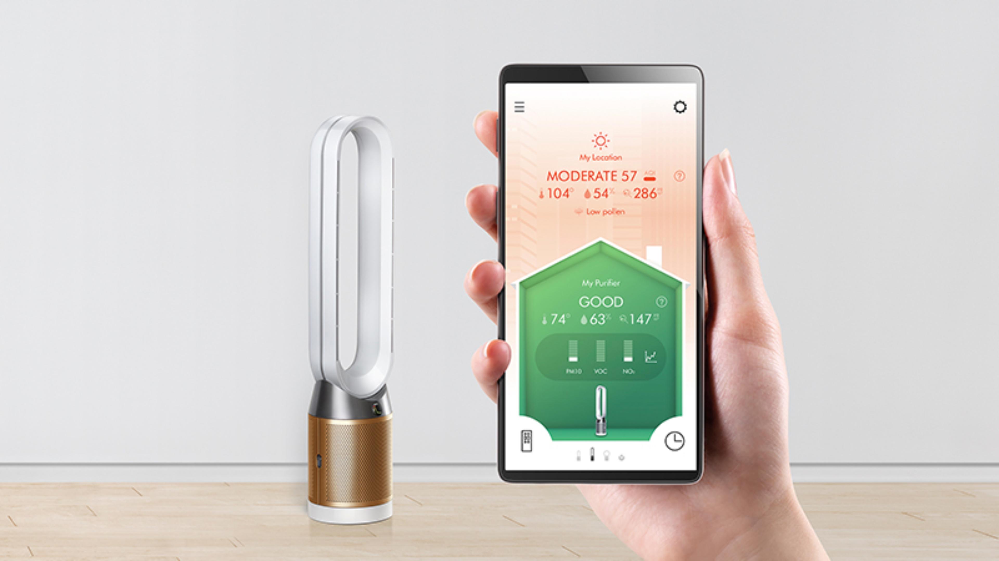 Một tay cầm điện thoại thông minh trước máy lọc Dyson. Màn hình điện thoại hiển thị ứng dụng Dyson Link.