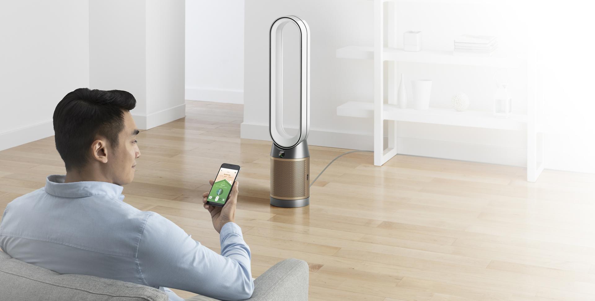 Man controlling Dyson Purifier with Dyson Link app