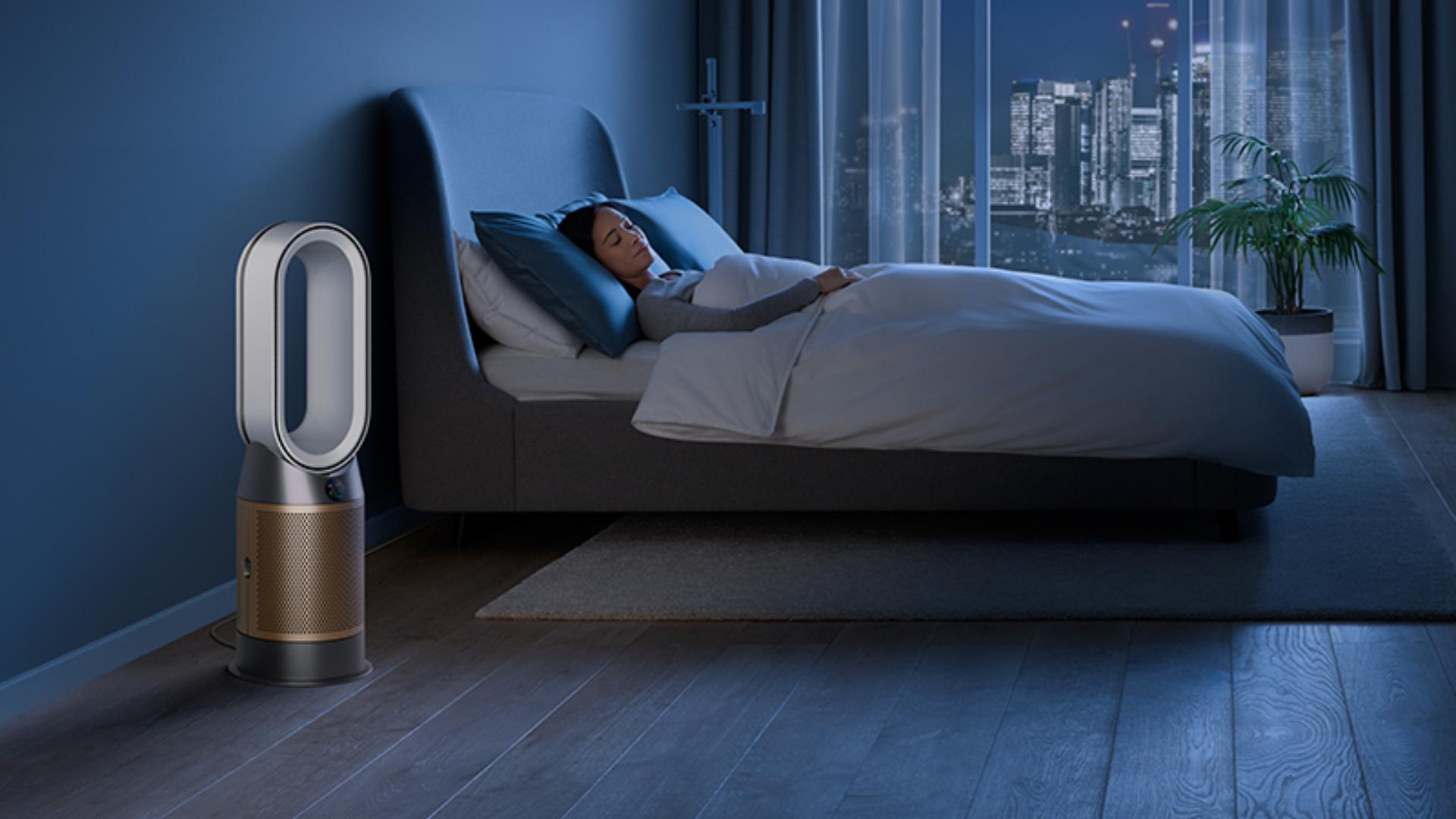 Dyson air purifier in a dark bedroom with someone sleeping peacefully