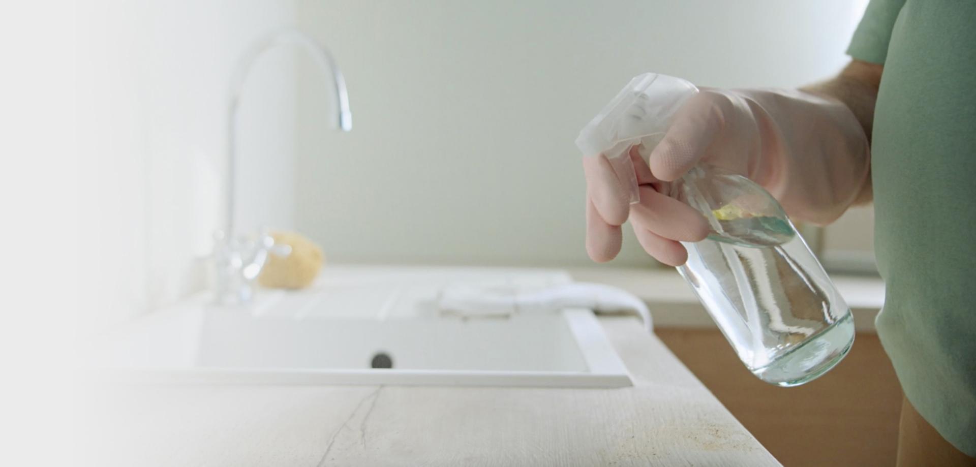Cleaning the surfaces by a kitchen sink.