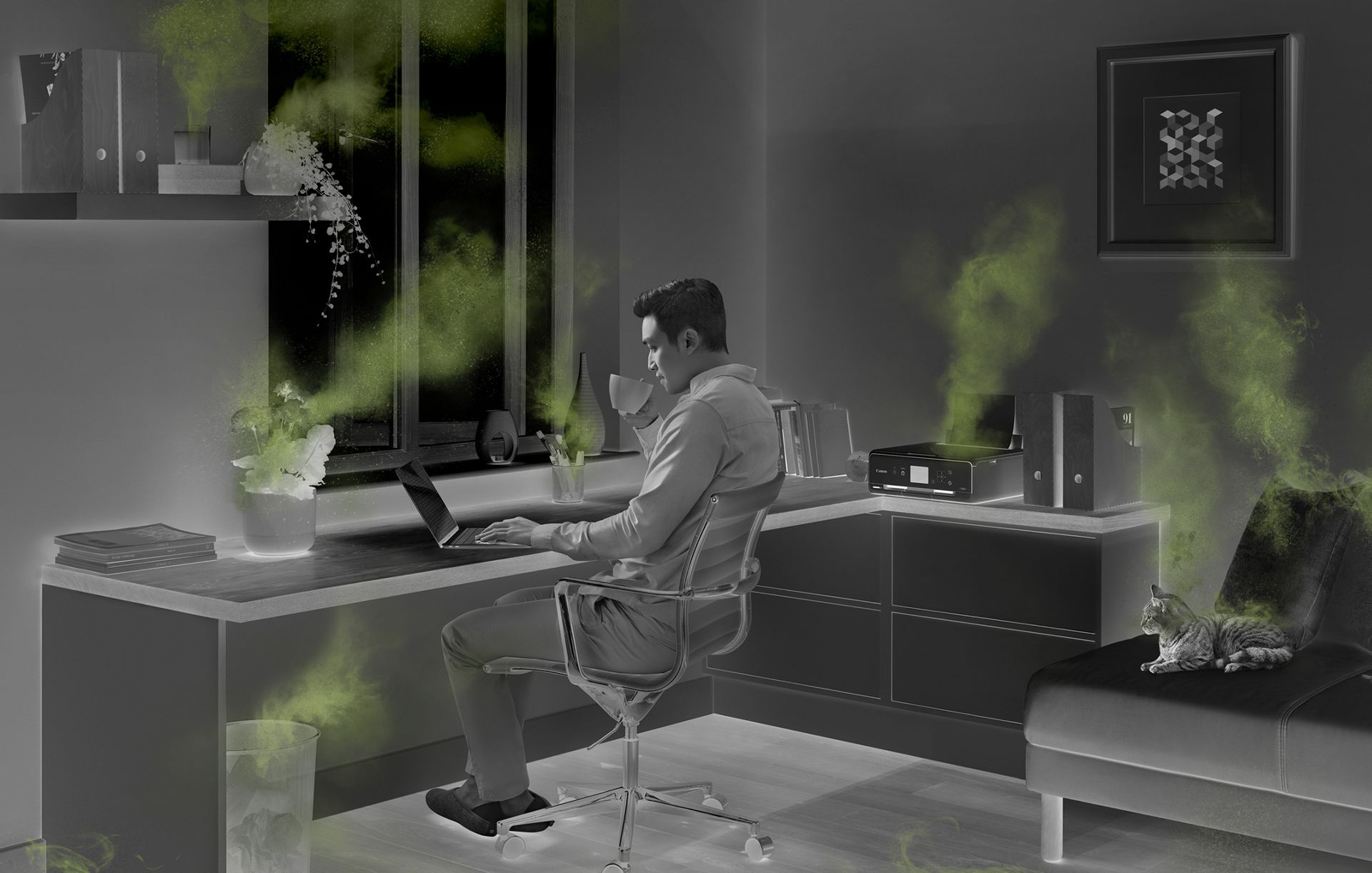 Man working in a home office, surrounded by sources of indoor air pollution