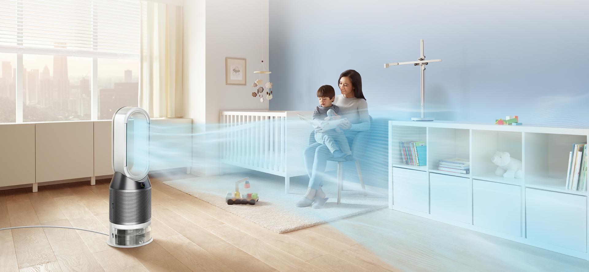 A woman reads to her child while the Dyson purifier humidifier fan projects a stream of air through his bedroom