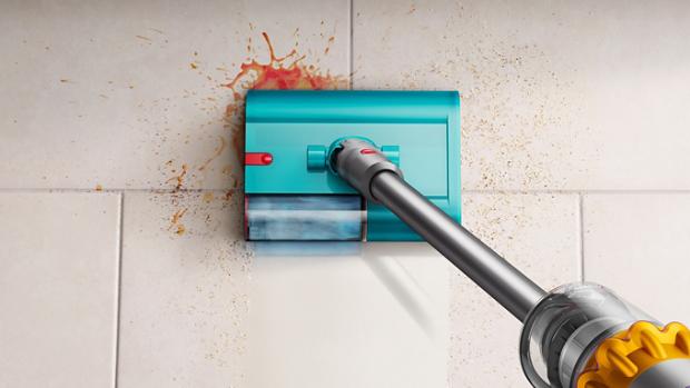 مشهد علوي لمكنسة تنظيف رطب وجاف من دايسون بينما تُزيل المخلفات والانسكابات من على أرضية بلاط