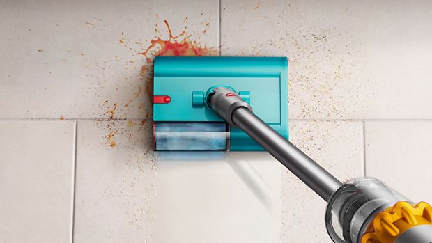 مشهد علوي لمكنسة تنظيف رطب وجاف من دايسون بينما تُزيل المخلفات والانسكابات من على أرضية بلاط