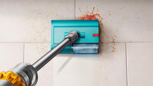 An aerial view of a Dyson wet and dry cleaner removing debris and spills on a tile floor