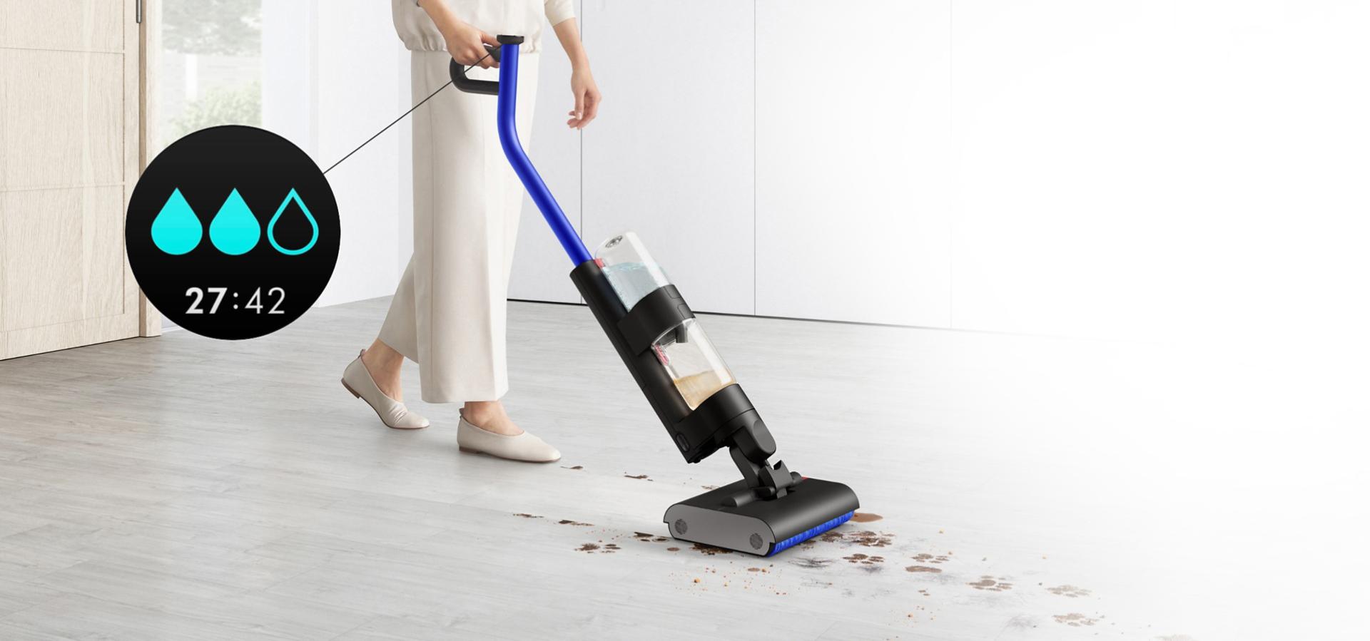 مستخدم يُنظِّف أرضية صلبة في منطقة معيشة وتظهر قطرات ماء على شاشة LCD للإشارة إلى مستوى الترطيب الأول