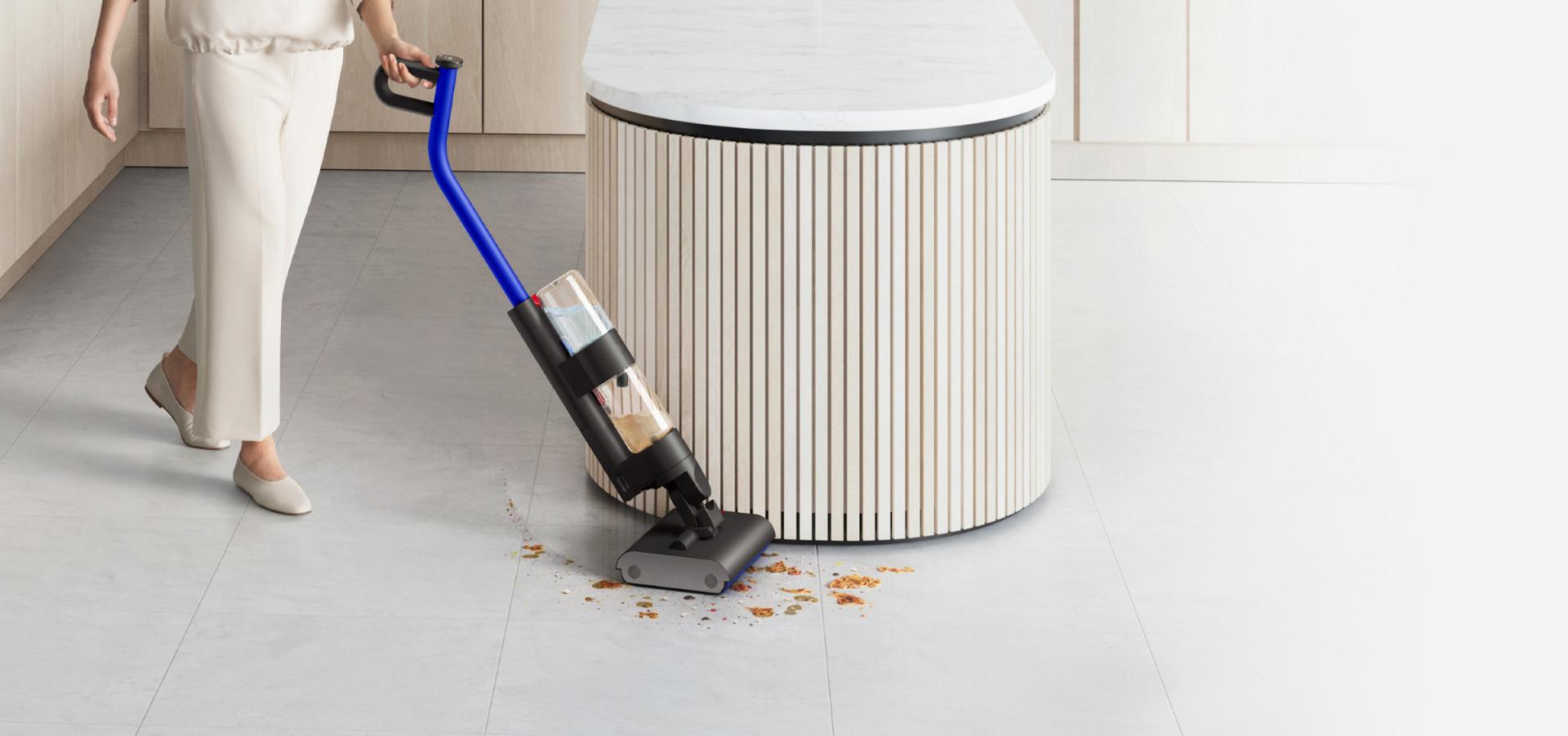 مستخدم يُنظِّف أرضية صلبة باستخدام Dyson WashG1 في مساحة معيشة كبيرة