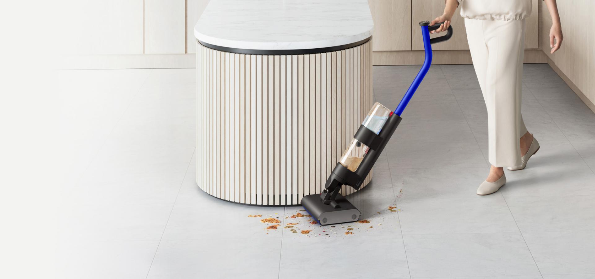 A user cleaning a hard floor with Dyson WashG1 in a large living space