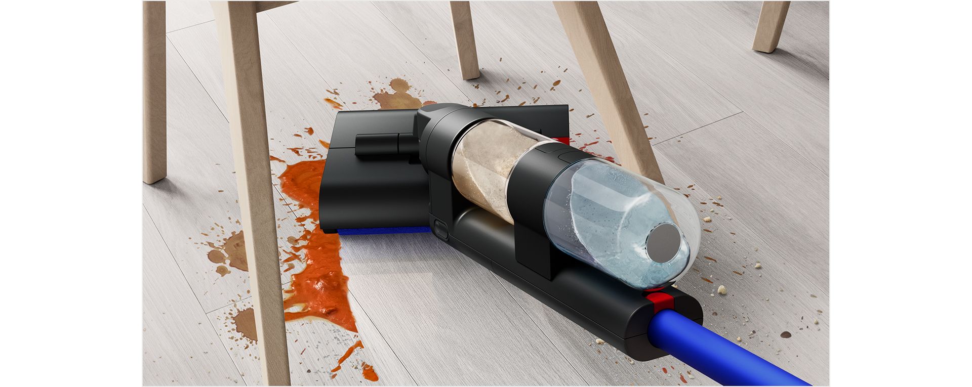 A user gliding the Dyson WashG1 wet cleaner to remove large food spills under a dining chair