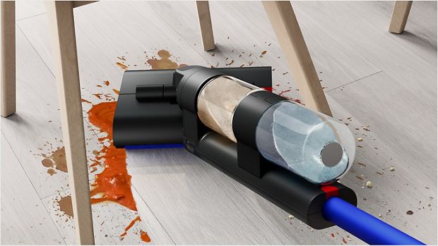 A user gliding the Dyson WashG1 wet cleaner to remove large food spills under a dining chair