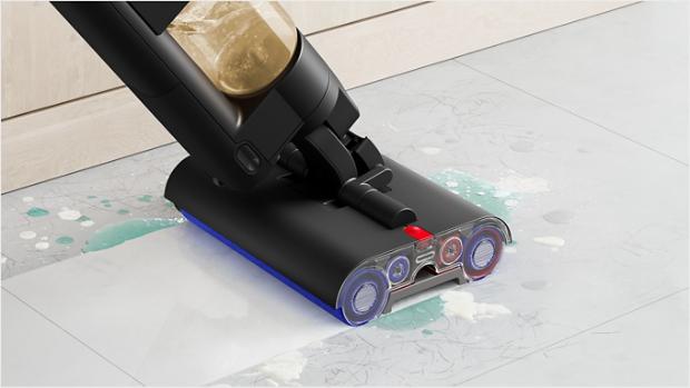 A close-up of the Dyson WashG1 wet cleaner tackling muddy pawprints on a hard floor