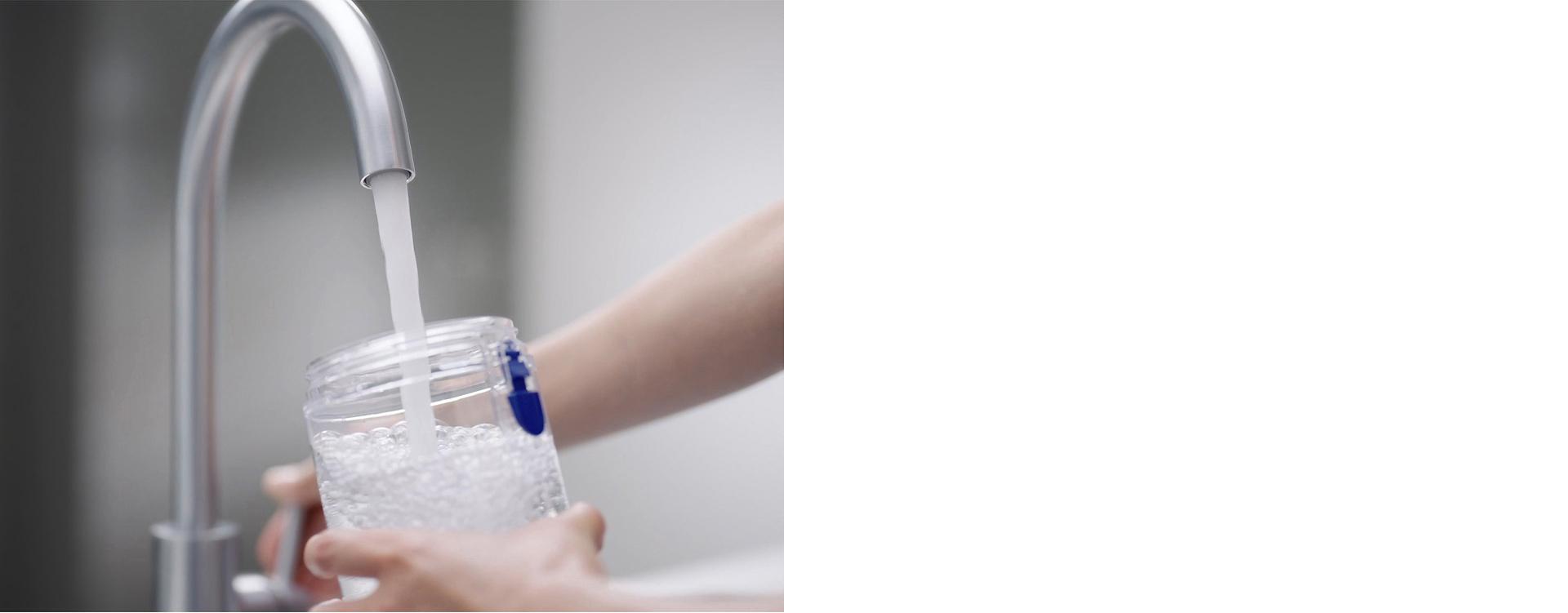 Naudotojas plauna talpyklą tekančiu vandeniu