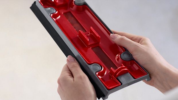 A user holding the Debris tray