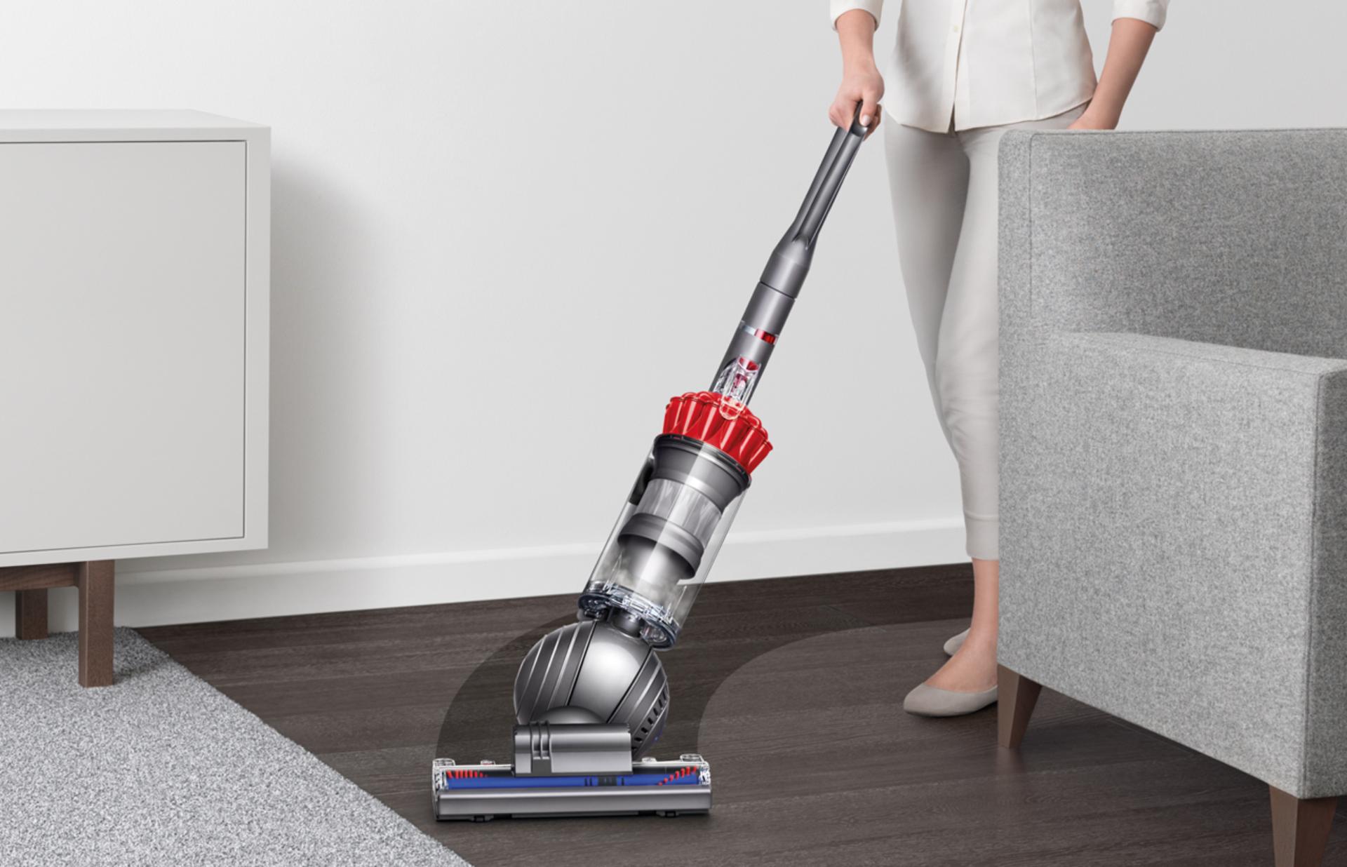 A man vacuuming floor using the Dyson upright vacuum cleaner