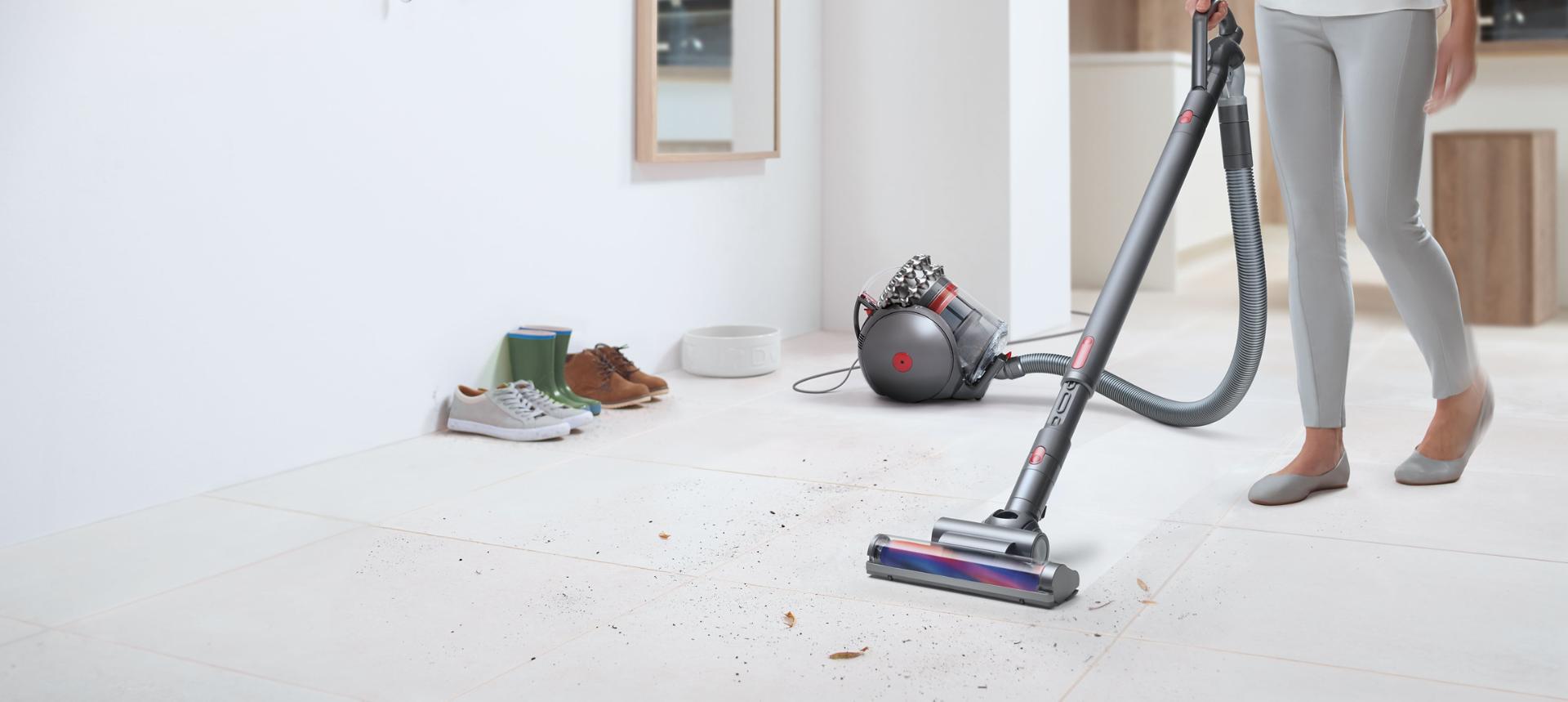 Woman using the Dyson Cinetic Big Ball to clean a living room