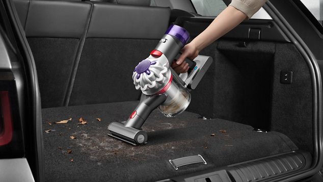 Dyson V8 vacuum in handheld mode vacuuming a car