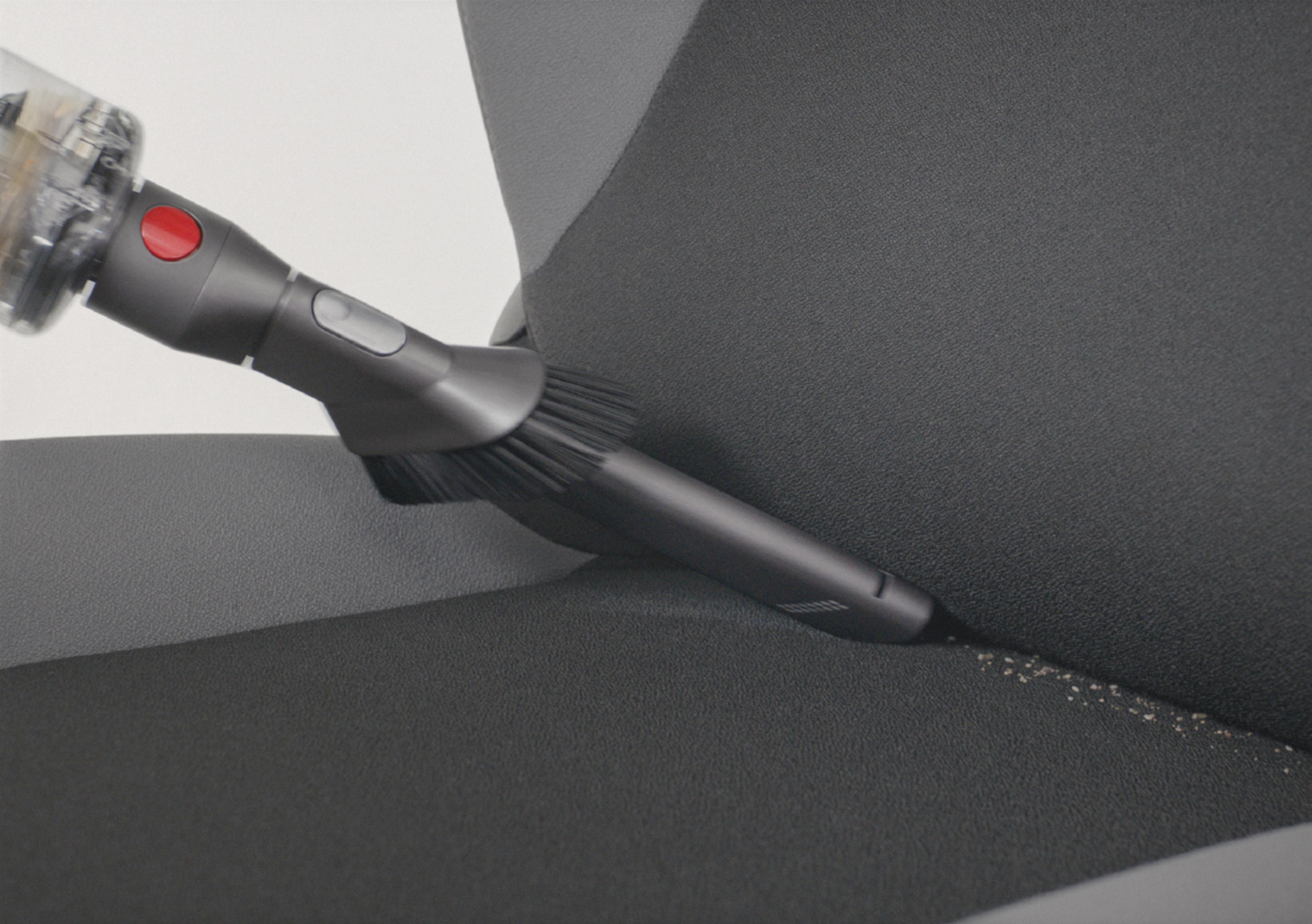 Dyson Omni-glide z zamontowaną końcówką szczelinową sprząta siedzenie samochodu
