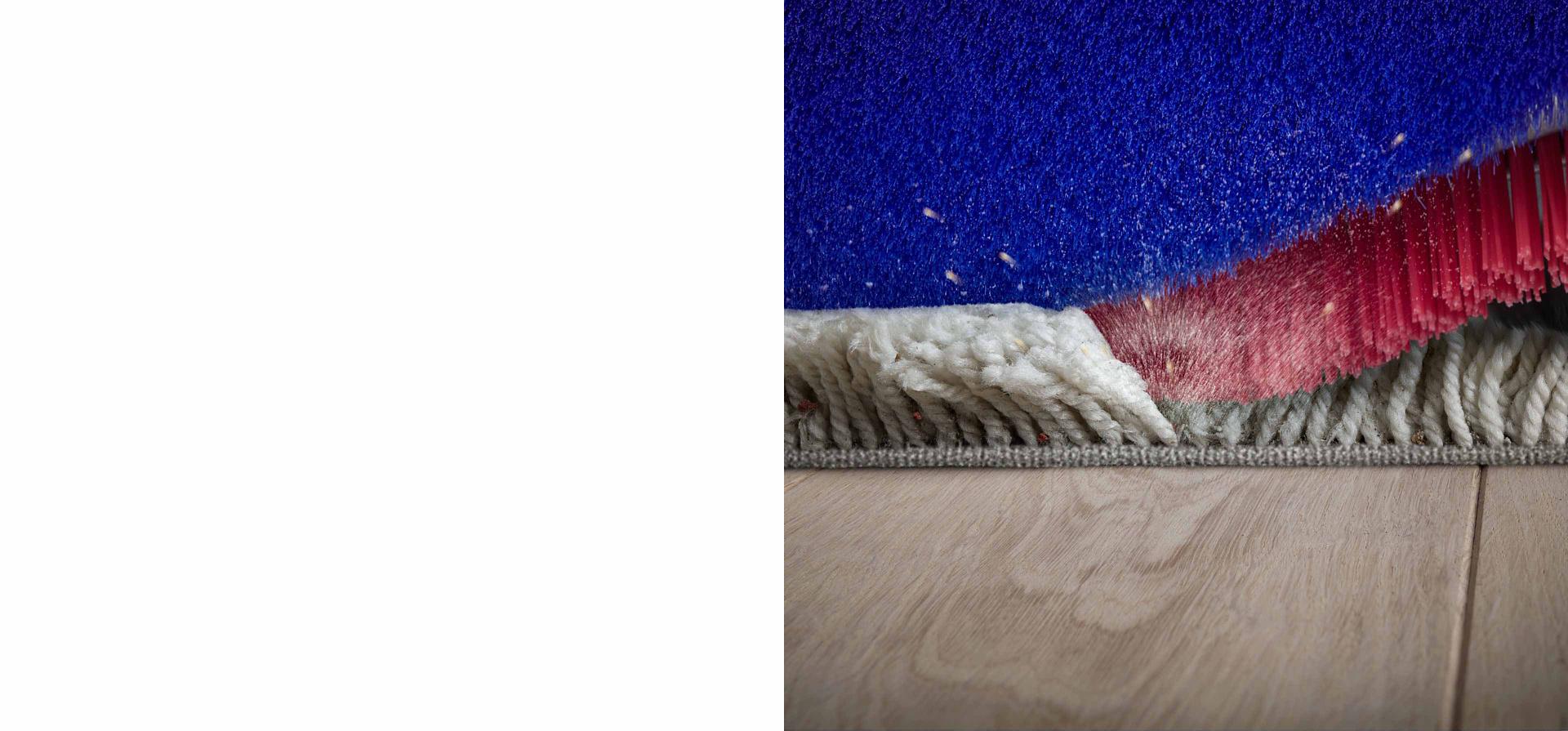 Dyson 360 VisNav™ 的高密度硬尼龍刷毛從深絨地毯清除塵垢的特寫圖