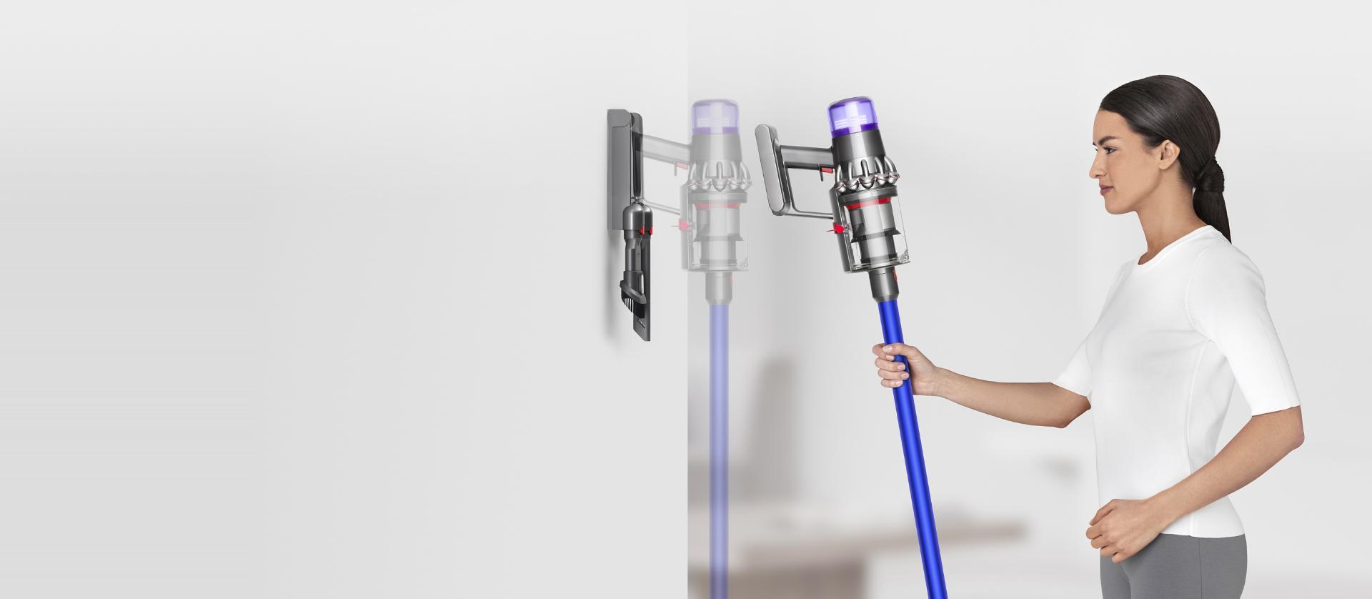 Woman placing Dyson V11™ vacuum into wall charging dock