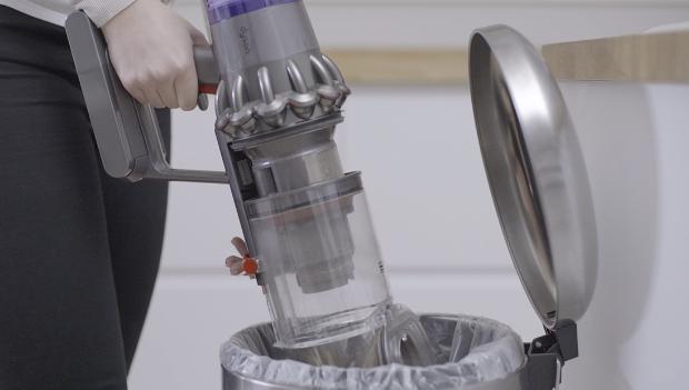 一位男士正在清空Dyson V11™無線吸塵機的集塵筒