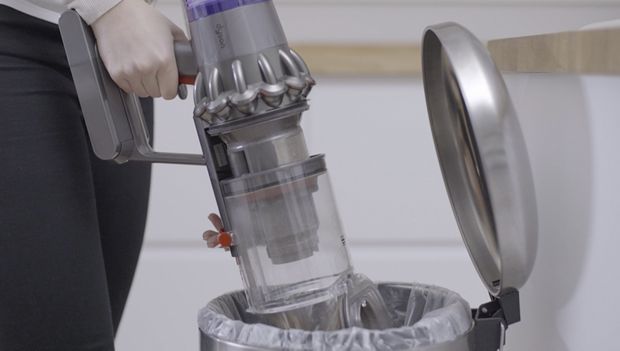 一位男士正在清空Dyson V11™無線吸塵機的集塵筒
