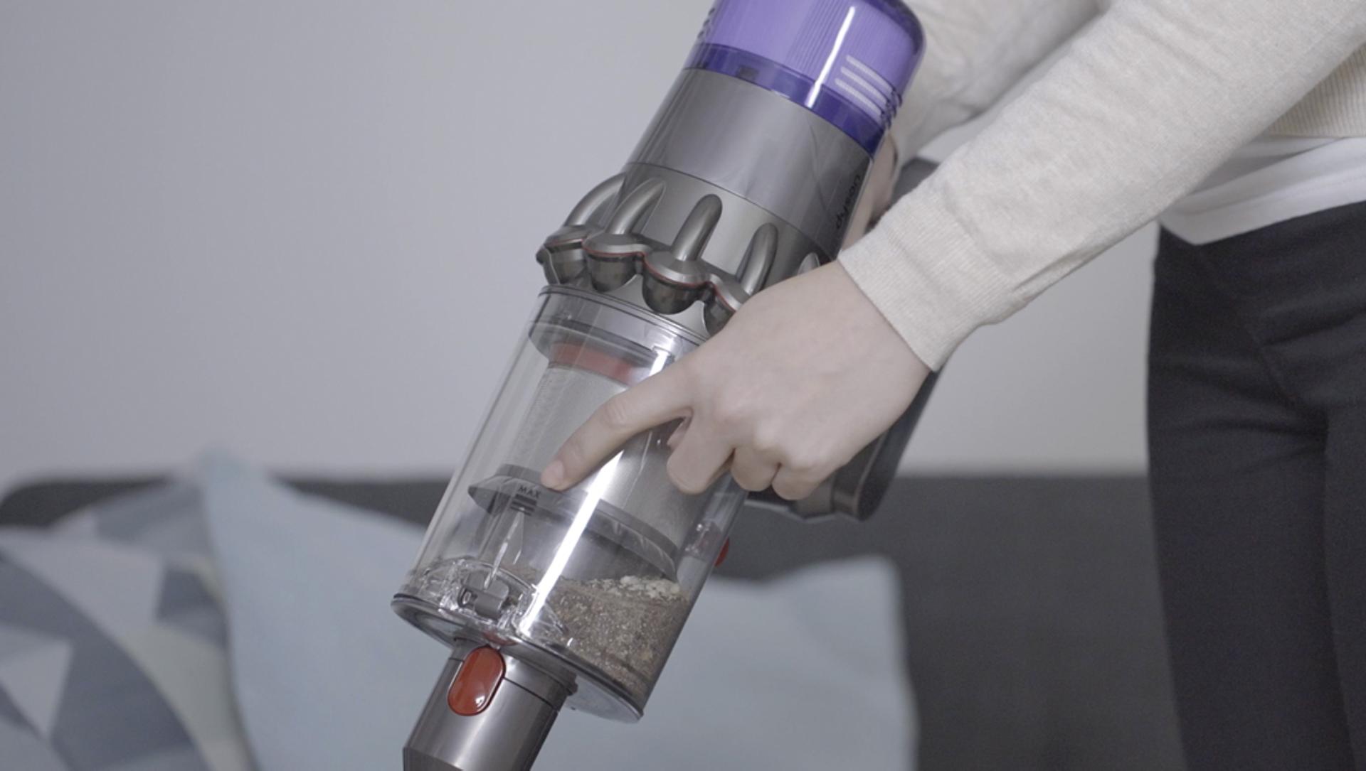 一位女士正在指出Dyson V11™無線吸塵機集塵筒的「最大」指標
