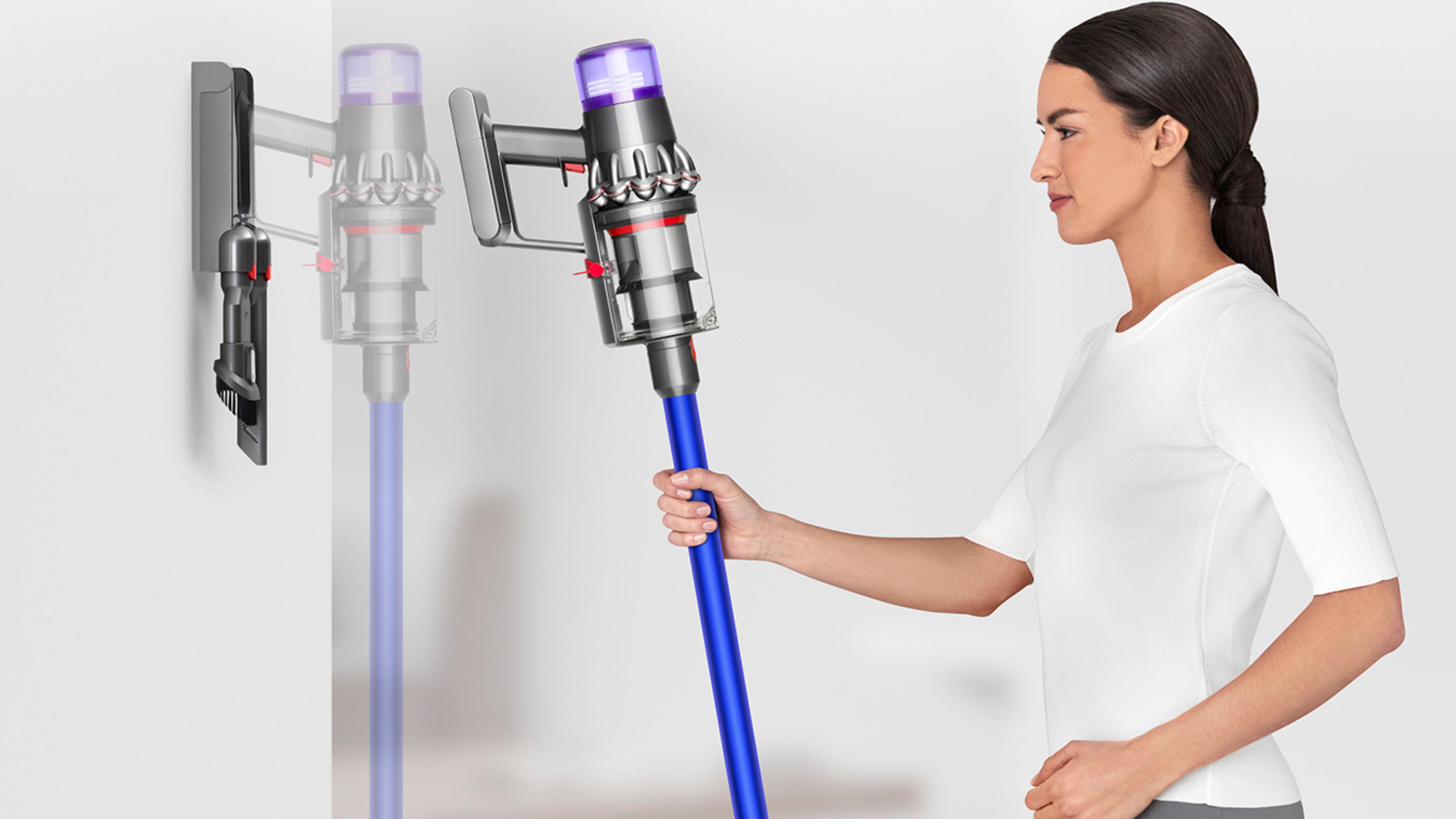 Woman placing Dyson V11™ vacuum into wall charging dock