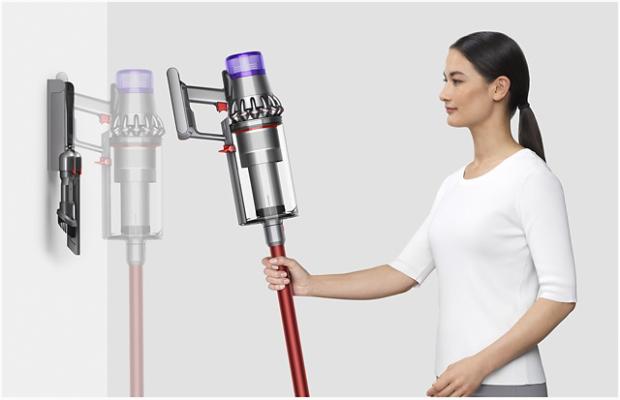 Woman placing Dyson V11™ vacuum into wall charging dock