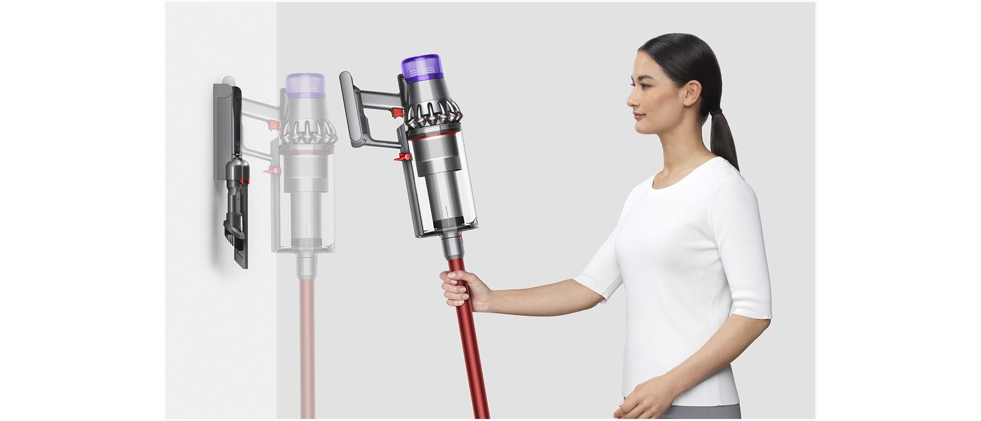 Woman placing Dyson V11™ vacuum into wall charging dock