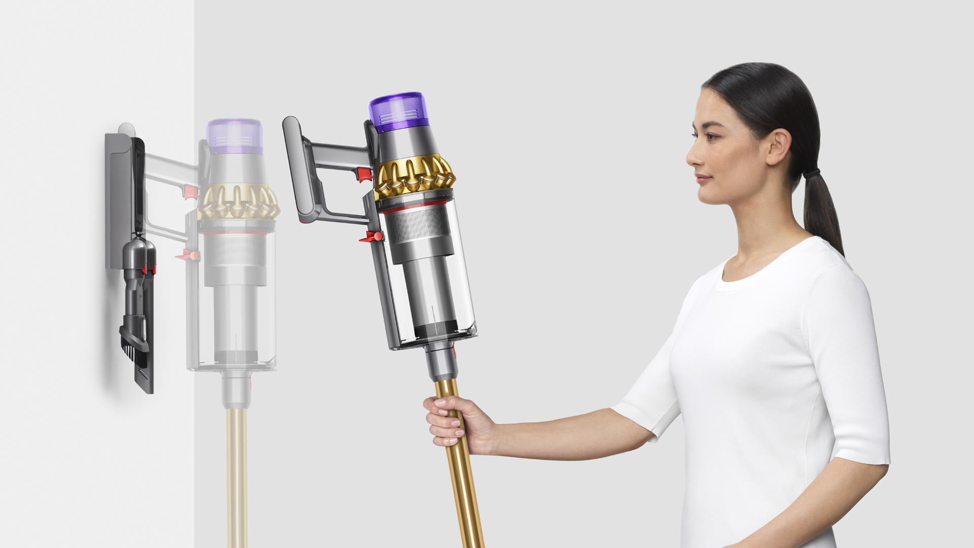 Woman placing Dyson V11 Outsize vacuum into wall charging dock