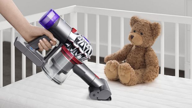 Dyson V8 Slim vacuum in handheld mode cleaning a mattress