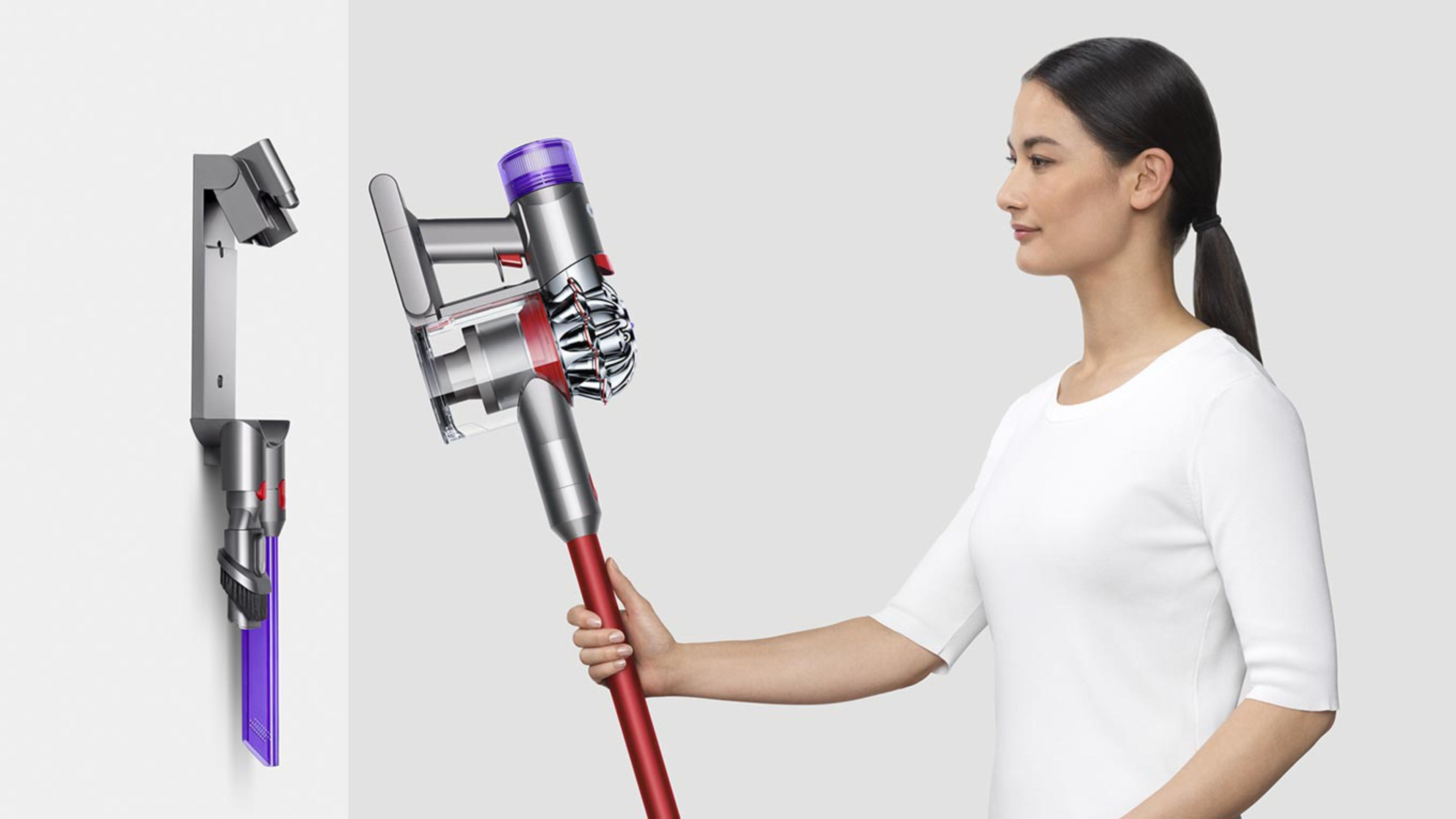 A lady returning the Dyson V8™ vacuum to the charging dock
