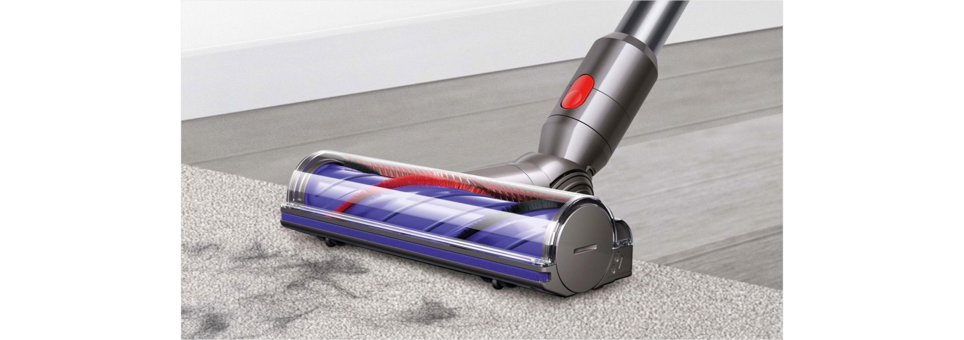 Dyson Cyklon V10-støvsugerens roterende støvsugerhoved opsamler snavs over flere forskellige gulvoverflader.