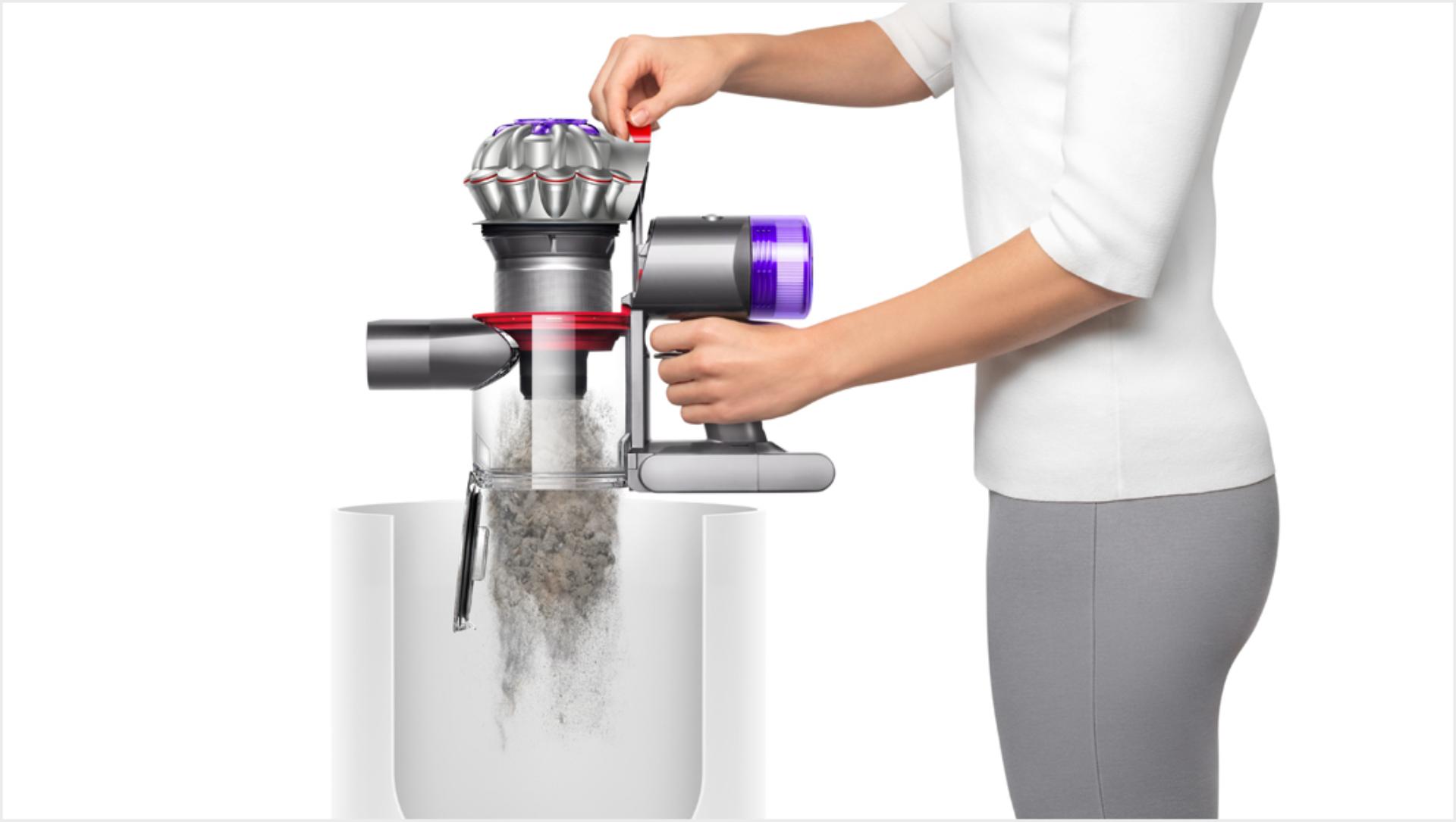 Женщина опорожняет пылесос Dyson V8