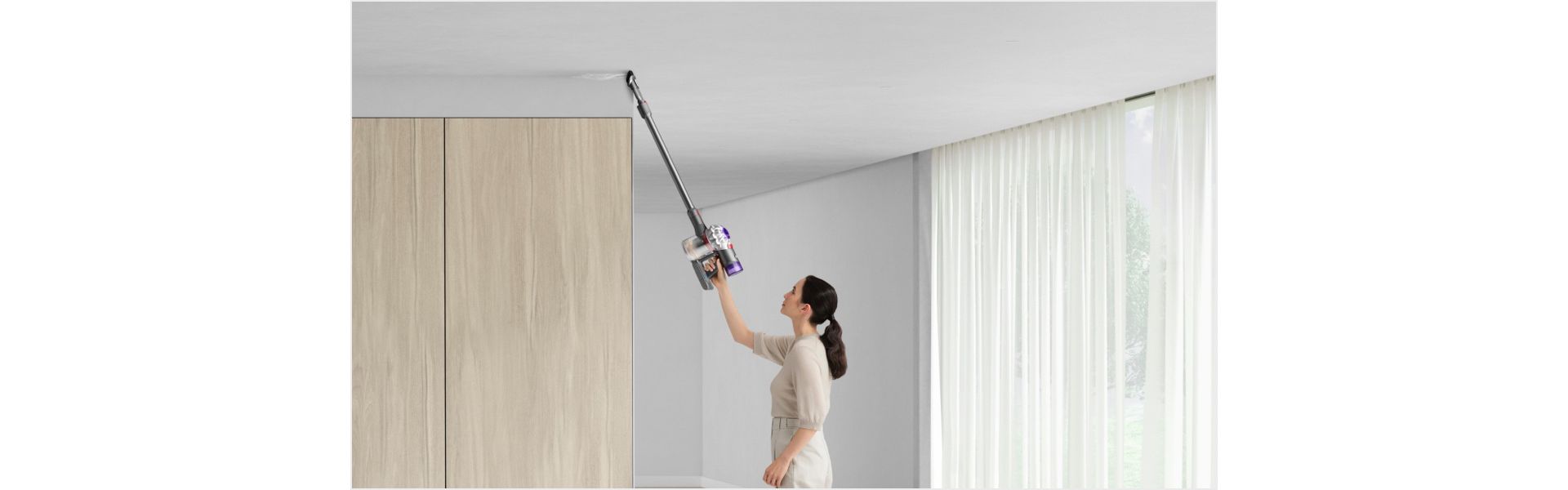 Woman cleaning up high with Dyson V8 vacuum