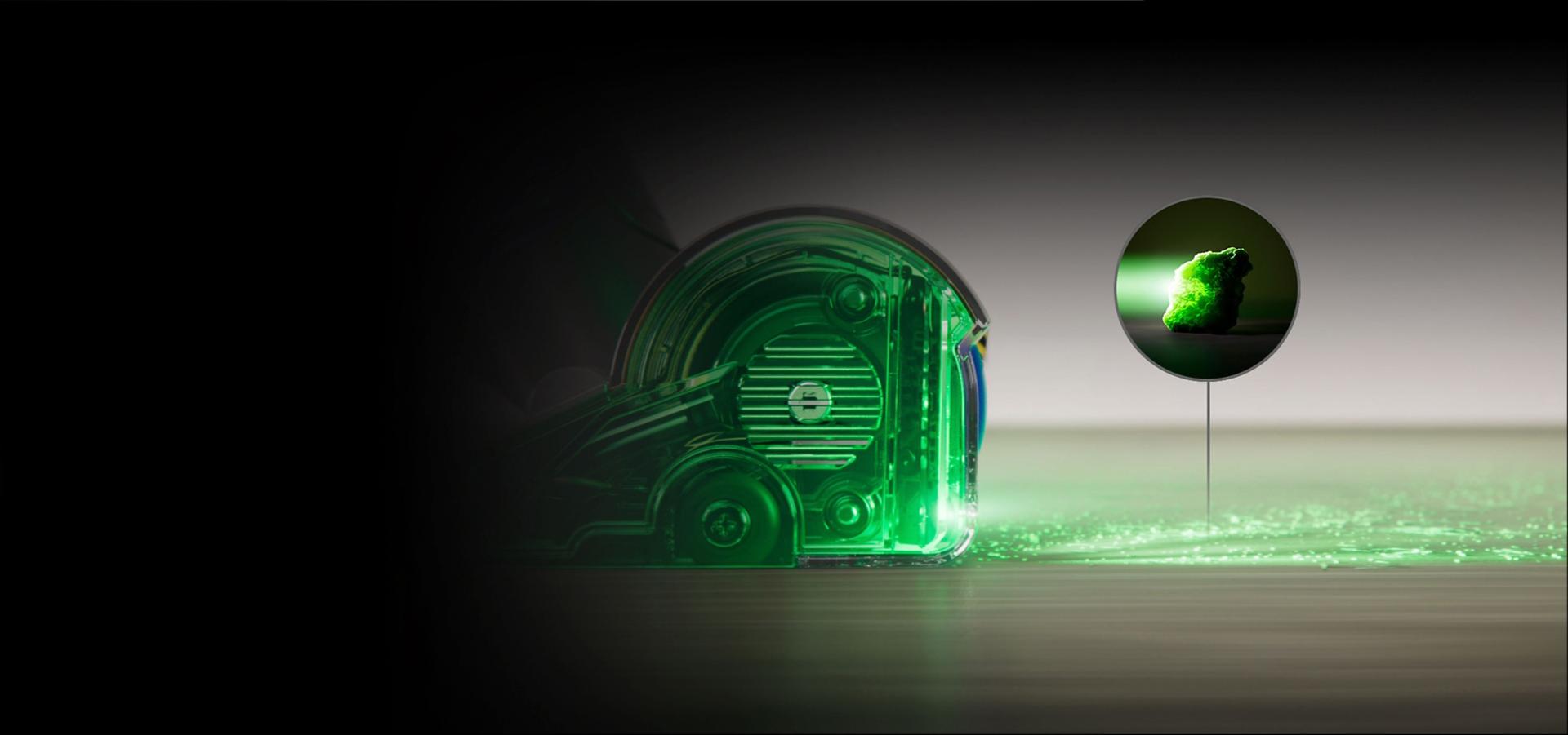 Bočni prikaz usisavača s fluorescentnim zelenim svjetlo koje prolazi kroz glavu usisavača i prema podu.