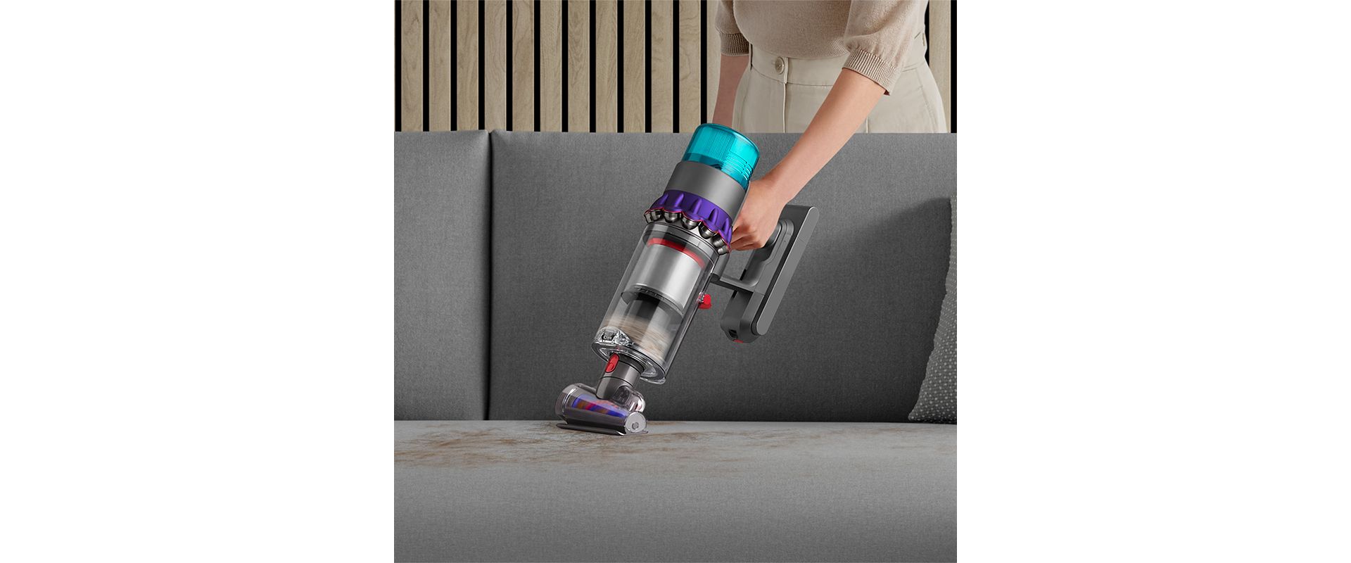 De-tangling Hair screw tool vacuuming a sofa.