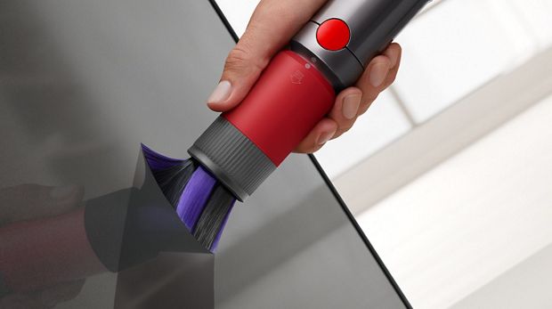 Cepillo quitapolvo antirayones limpiando alrededor de un espejo delicado.