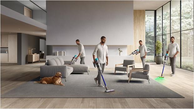 Man vacuuming his home with the Dyson Gen5outsize using the Motorbar cleaner head and Built-in dusting and crevice tool.