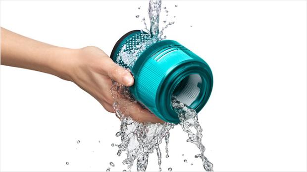 Dyson filter being rinsed under a tap.