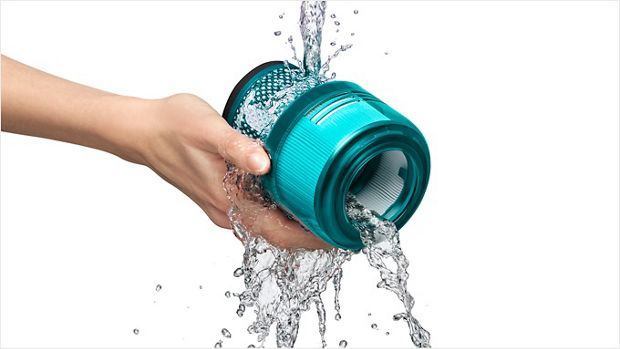 Dyson filter being rinsed under a tap.